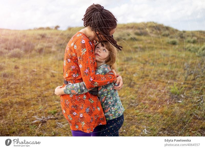 Mutter und Tochter umarmen im Freien Kind Familie Natur Hipster Rastalocken umarmend Liebe Erwachsener schön Schönheit Kindheit Kultur Kleid Frau Feld Spaß