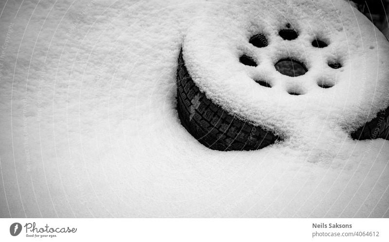 Autorad liegt am Straßenrand und ist mit einer dicken Schneeschicht bedeckt Automobil Hintergrund schwarz PKW Wandel & Veränderung kreisen Detailaufnahme Donuts