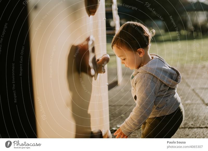 Kind spielt auf dem Spielplatz Kaukasier 1-3 Jahre authentisch Spielen Kletterwand Park Fröhlichkeit Glück Kleinkind Tag Kindheit Mensch Farbfoto Außenaufnahme