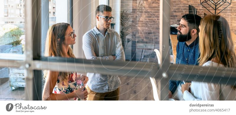 Personen bei einem Geschäftstreffen im Büro Teamwork Mitarbeiter sprechend Ärger Sitzung Stehen Widerspruch Glastrennwand Geschäftsleute Inbetriebnahme