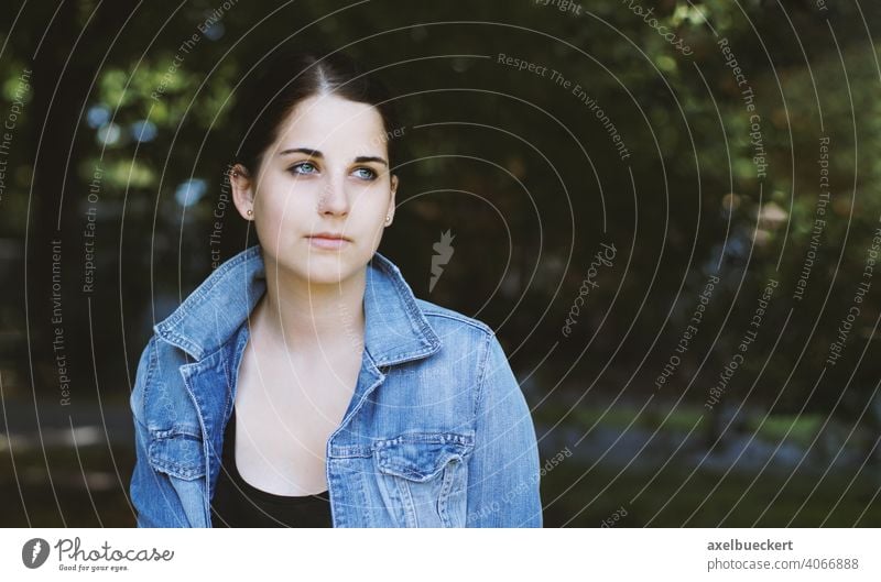 verträumte junge Frau im Freien mit Blick in die Ferne Teenager echte Menschen Tagträumen Mädchen Park Natur authentisch Jugend hübsch dunkles Haar