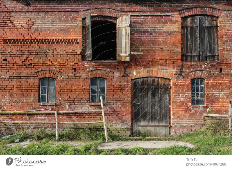 die Fassade eines Stallgebäudes stallung Bauernhof Landwirtschaft Farbfoto Menschenleer Außenaufnahme Tag Hof agriculture Scheune Gebäude Dorf Tür ländlich Wand