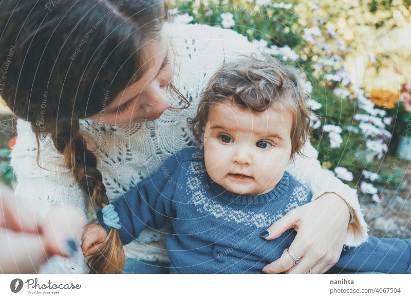 Junge Mutter umarmt ihr Baby und genießt einen Frühlingstag im Garten Familie Mama Lifestyle Liebe Pflege Kind Kindheit Blumen Natur natürlich Hippie im Freien