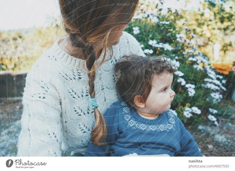 Junge Mutter umarmt ihr Baby und genießt einen Frühlingstag im Garten Familie Mama Lifestyle Liebe Pflege Kind Kindheit Blumen Natur natürlich Hippie im Freien