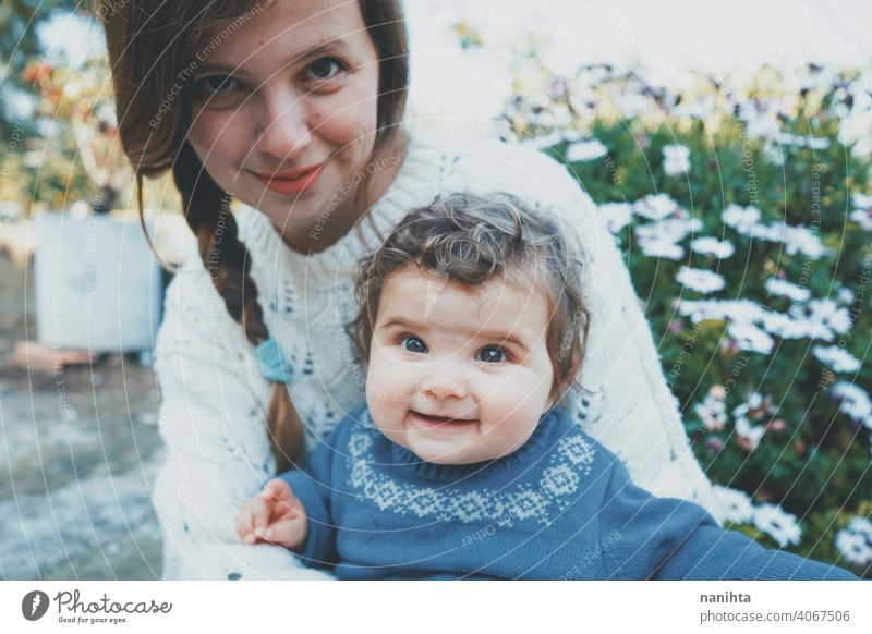 Junge Mutter umarmt ihr Baby und genießt einen Frühlingstag im Garten Familie Mama Lifestyle Liebe Pflege Kind Kindheit Blumen Natur natürlich Hippie im Freien