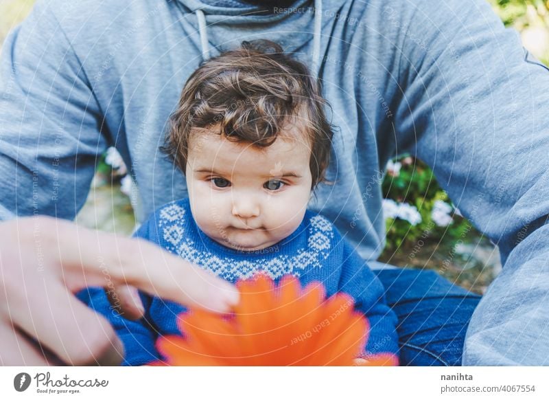 Kleines Baby, das zum ersten Mal eine riesige Blume entdeckt entdecken Frühling Fröhlichkeit Familie Familienzeit Papa Vater Mädchen Kind Kleinkind 9 Monat