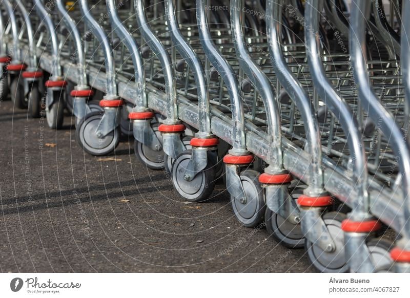 Einkaufswagen, die auf dem Parkplatz und im Eingangsbereich eines riesigen Lagerhaus-Supermarktes am Rande der Stadt Zaragoza, Spanien, angeordnet sind.