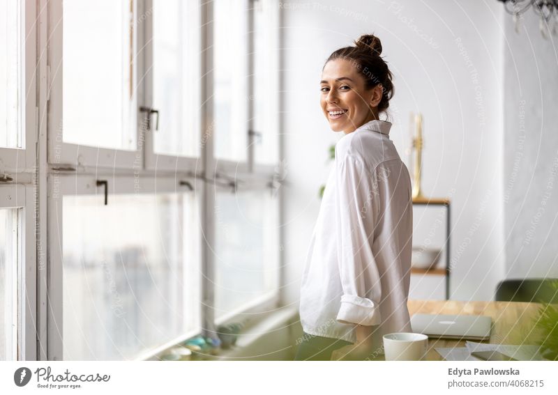 Porträt einer lächelnden kreativen Frau in einem modernen Loft-Raum Jahrtausende Schüler Hipster im Innenbereich Fenster natürlich Mädchen Erwachsener attraktiv