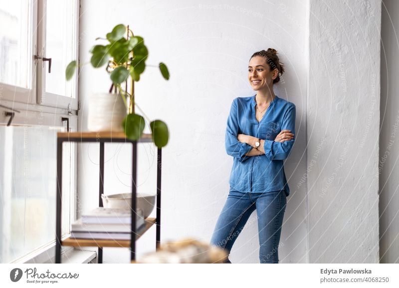 Porträt einer lächelnden kreativen Frau in einem modernen Loft-Raum Jahrtausende Schüler Hipster im Innenbereich Fenster natürlich Mädchen Erwachsener attraktiv