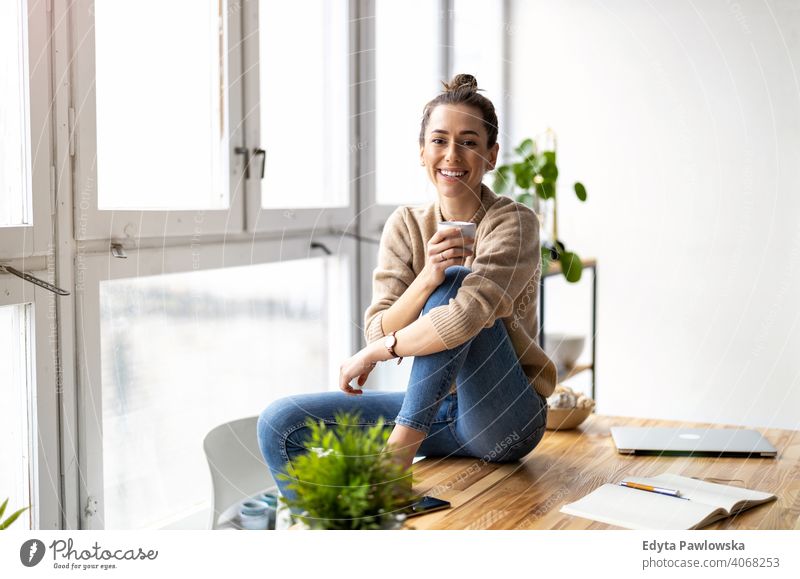 Porträt einer lächelnden kreativen Frau in einem modernen Loft-Raum Jahrtausende Schüler Hipster im Innenbereich Fenster natürlich Mädchen Erwachsener attraktiv