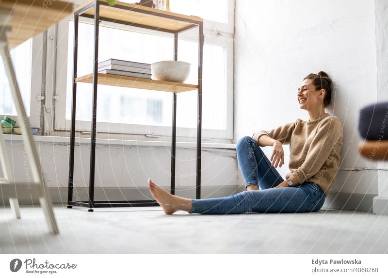 Porträt einer lächelnden kreativen Frau in einem modernen Loft-Raum Jahrtausende Schüler Hipster im Innenbereich Fenster natürlich Mädchen Erwachsener attraktiv