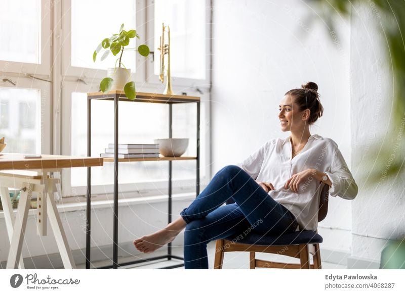 Porträt einer lächelnden kreativen Frau in einem modernen Loft-Raum Jahrtausende Schüler Hipster im Innenbereich Fenster natürlich Mädchen Erwachsener attraktiv