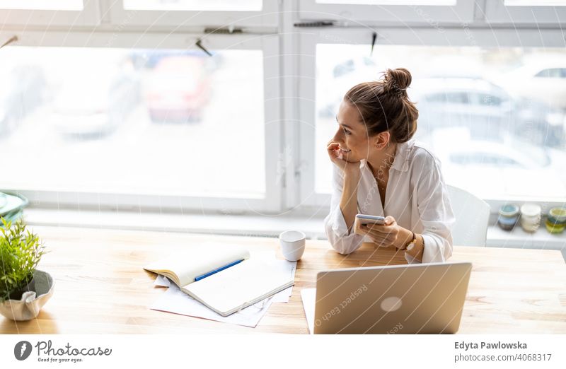 Junge Frau, die in einem kreativen Start-up-Unternehmen arbeitet Jahrtausende Schüler Hipster im Innenbereich Loft Fenster natürlich Mädchen Erwachsener