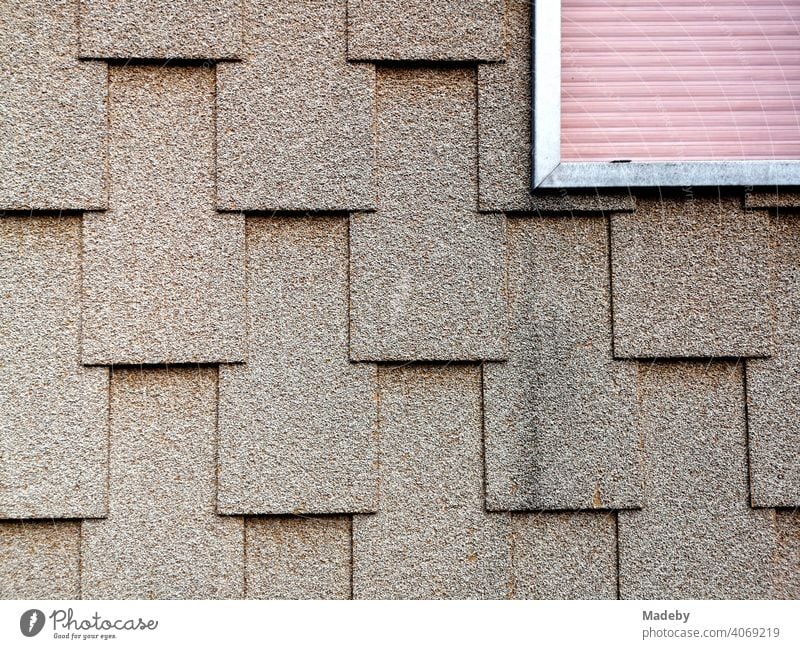 Fassadengestaltung mit rechteckigen Schindeln und umrahmter Rollladen in der naturfarbenen Fassade eines Wohnhaus in Wettenberg Krofdorf-Gleiberg bei Gießen in Hessen