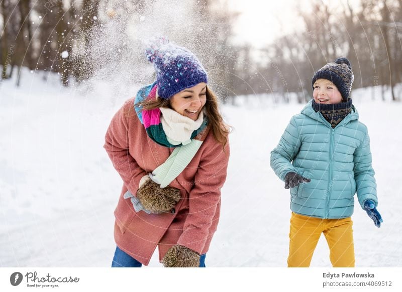 Mutter und Kind mit Schneeballschlacht im Winter Park Sohn Tochter Saison Zusammensein gefroren heiter Spaß Menschen Feiertag Wald Kindheit Frau Mädchen Natur