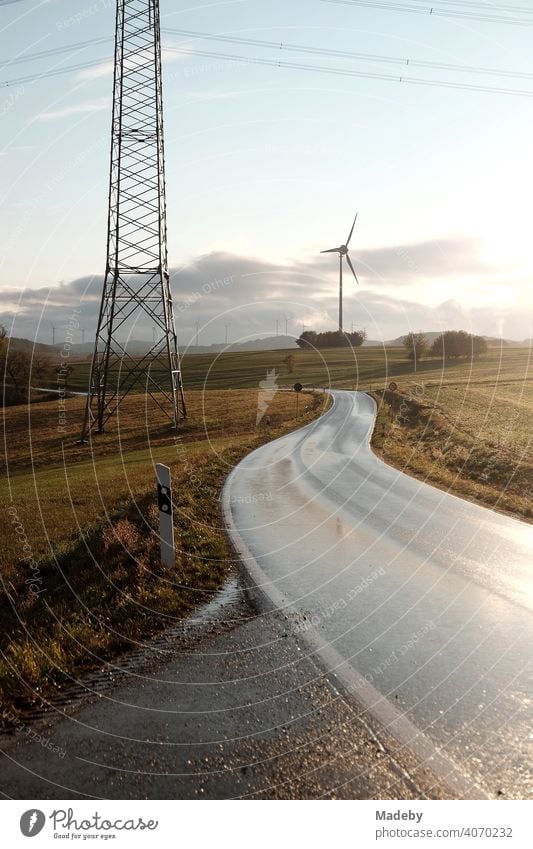 Landstraße nach einem Gewitter mit Regenschauer, Strommast und Windrad in Gembeck am Twistetal im Kreis Waldeck-Frankenberg in Hessen Straße Kurve Nass Nässe