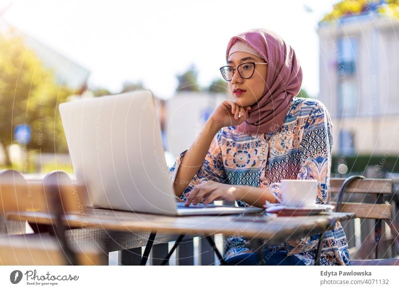 Junge muslimische Frau, die einen Laptop in einem Straßencafé benutzt Hijab Kopftuch Islam arabisch Sommer Mädchen Menschen junger Erwachsener Lifestyle aktiv