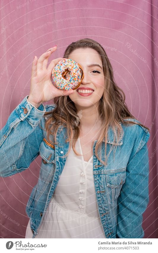 Schöne Frau hält einen Donut. attraktiv Hintergrund Bäckerei schön Schönheit heiter farbenfroh Konditorei niedlich lecker Dessert Krapfen Donuts Doughnut Ostern