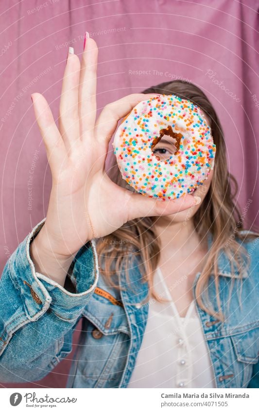 Schöne Frau hält einen Donut. attraktiv Hintergrund Bäckerei schön Schönheit heiter farbenfroh Konditorei niedlich lecker Dessert Krapfen Donuts Doughnut Ostern