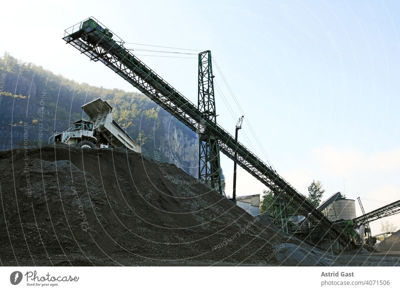 Eine Kiesgrube mit Arbeitsgeräten und LKW im Gebirge kieswerk lkw Industrie förderband Sand bauindustrie firma gebirge baugewerbe kiesgewinnung arbeiten