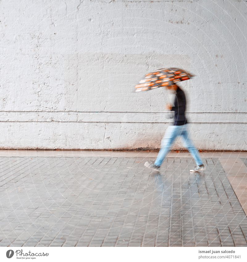 defokussiert Mann mit einem Regenschirm in regnerischen Tagen im Frühling Saison Menschen Person regnet Regentag Wasser menschlich Fußgänger Straße Großstadt