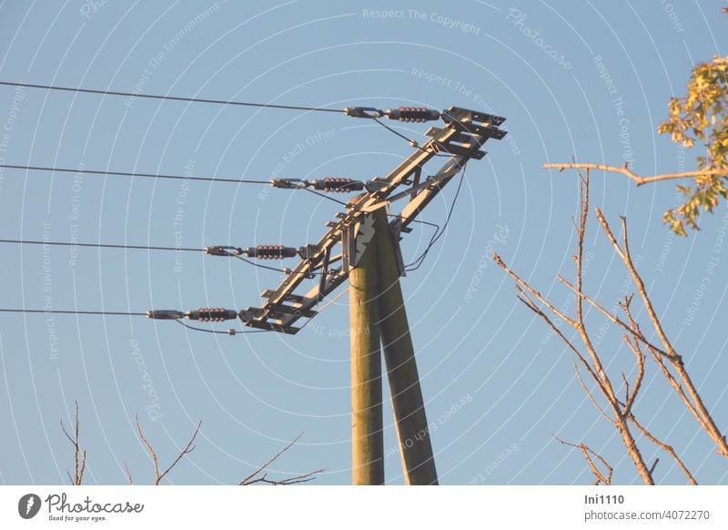 Strommast aus Holz mit vier Stromleitungen vor blauem Himmel ernergieversorgung CO2 Ernergiewirtschaft Technik & Technologie Metall Konstruktion Spannung