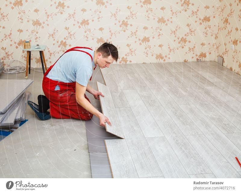 Handwerker beim Verlegen von Laminatböden kaschieren Installation Bodenbelag Konstruktion professionell Mechaniker arbeiten installieren im Innenbereich hölzern