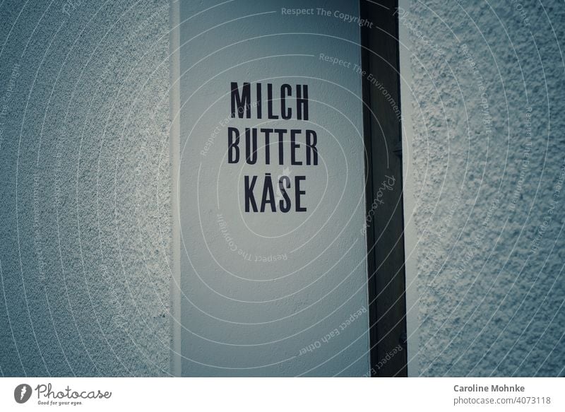 MILCH, BUTTER, KÄSE...Beschriftung einer ehemaligen Molkerei an einem Türeingang Milch Nahaufnahme Ernährung Butter Käse Lebensmittel frisch Essen zubereiten