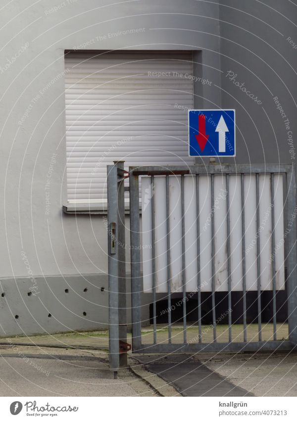 Verkehrszeichen 308 Vorrang vor Gegenverkehr Hinterhof Tor Außenaufnahme Tag Wand Mauer Haus Gebäude Fassade Fenster trist Menschenleer Farbfoto grau blau weiß