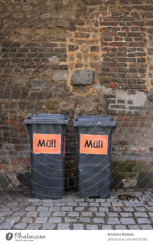 zwei graue mülltonnen mit der aufschrift müll schild aufkleber abfalleimer mülleimer hausmüll graue tonne restmüll restmülltonne entsorgung entsorgen draußen