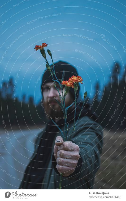 eine Blume schenkend Mann Nelken Übergabe Geben Schenken einer Blume Arbeiterhände Hand Person Halt eine Blume haltend Rosa Nelken geben Wald Natur