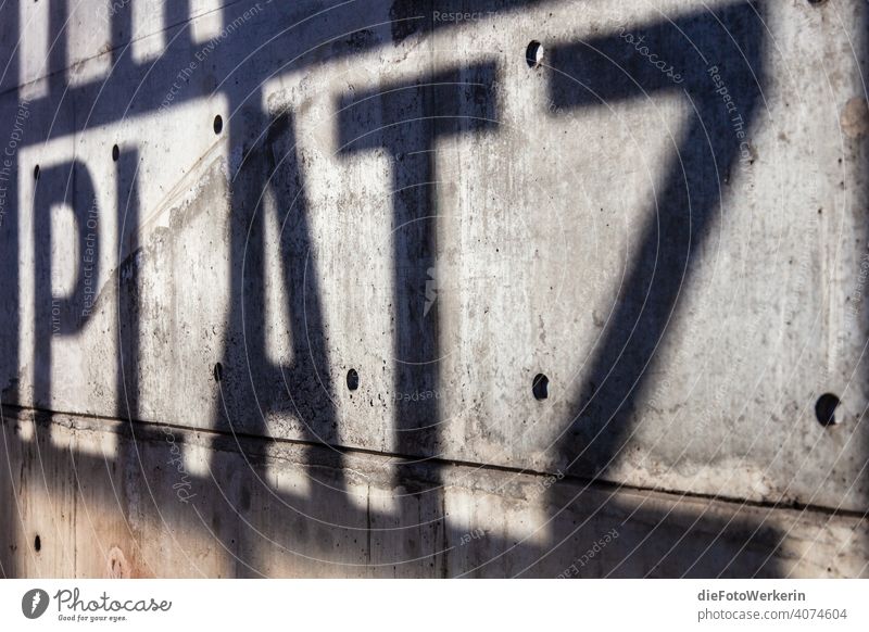 Schatten auf einer Wand, die das Wort „Platz" ergeben Deutschland Europa Information Köln Rheinland Text Westdeutschland grau schwarz Farbfoto Außenaufnahme