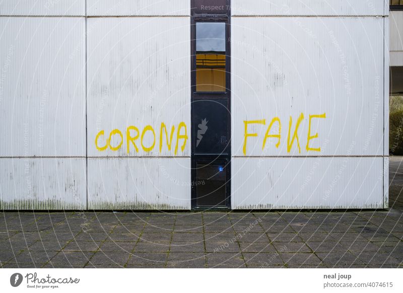 Gelbes Graffiti – Thema Corona – auf einer weißen Wand Krise Covid Wut Meinung Kommentar Pandemie Spruch Schrift Handschrift Virus Gesundheit Infektionsgefahr