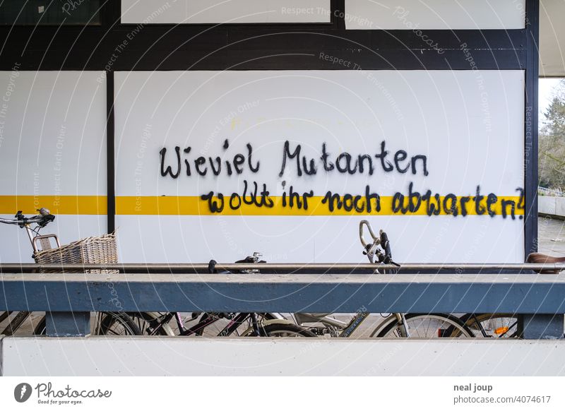 Graffiti – Thema Corona – auf einer weißen Wand mit gelbem Streifen Krise Covid Wut Meinung Kommentar Pandemie Spruch Schrift Handschrift Virus Gesundheit