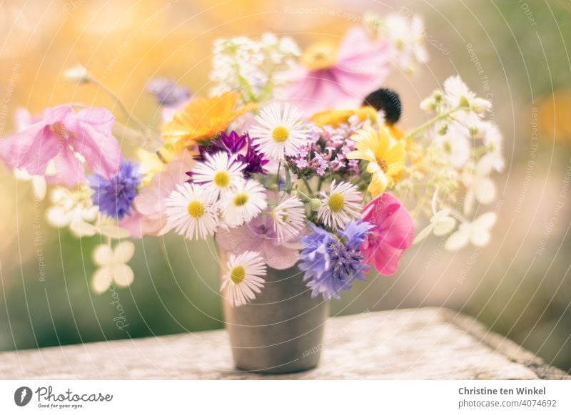 Ein kleiner romantischer Blumenstrauß mit Blümchen quer durch unseren Garten in einem alten Zinnbecher steht auf einer alten Weinkiste Gartenblumen