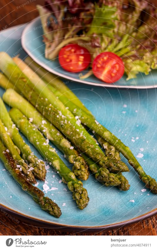 gegrillter grüner Spargel auf einem blauen Teller Planke Holz Saison saisonal Gourmet String Küche Zutaten Spargelstange Lebensmittel Stiel Frische rustikal