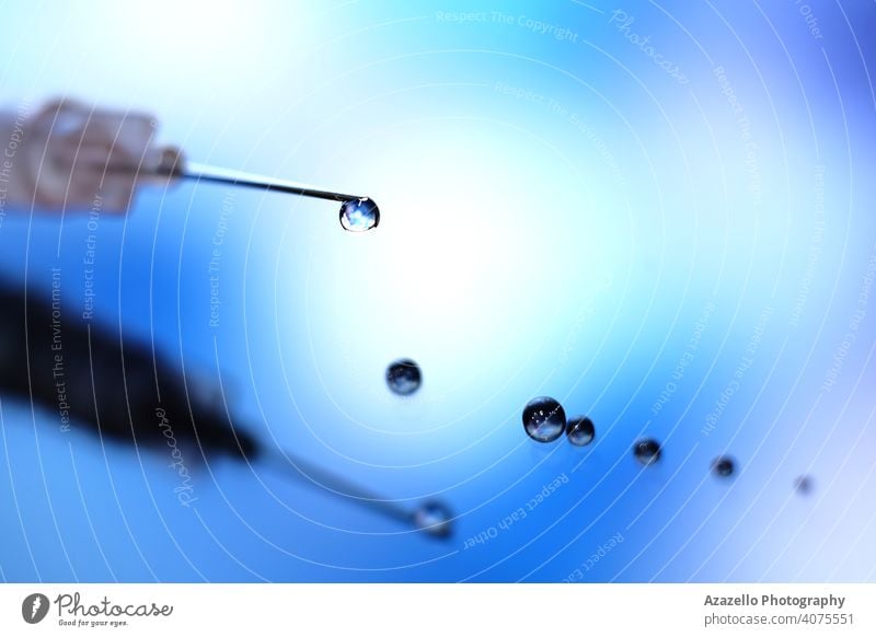 Nahaufnahme einer Spritze mit Tröpfchen auf der Nadel Sucht Ampulle Gegenmittel blau Bokeh Konzept Coronavirus dunkel Tod Abhängigkeit dramatisch Tropfen