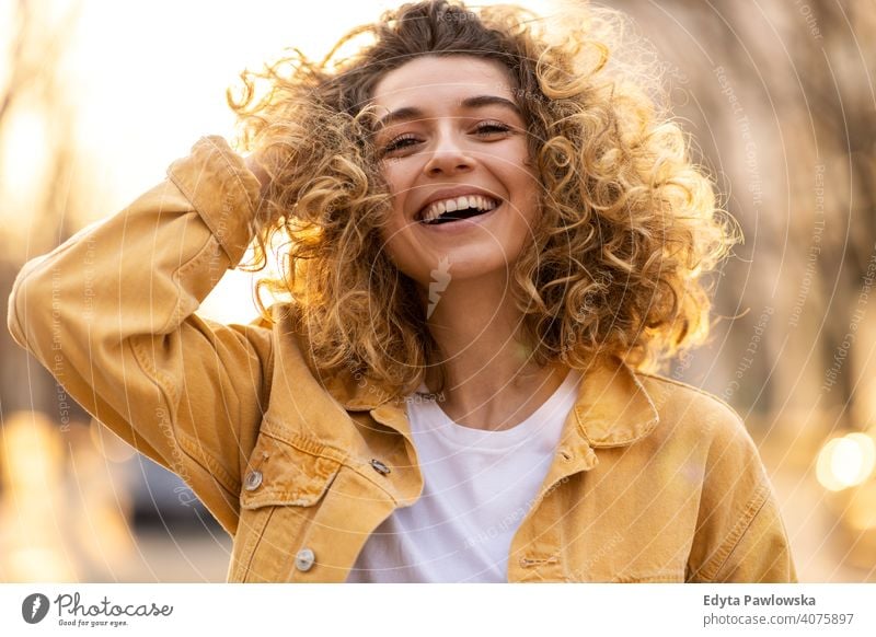 Porträt einer jungen Frau mit lockigem Haar in der Stadt natürlich Sonnenlicht urban Großstadt Hipster stylisch positiv sonnig cool Afro-Look Freude Gesundheit