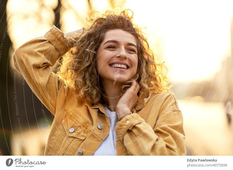 Porträt einer jungen Frau mit lockigem Haar in der Stadt natürlich Sonnenlicht urban Großstadt Hipster stylisch positiv sonnig cool Afro-Look Freude Gesundheit