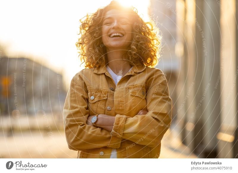 Porträt einer jungen Frau mit lockigem Haar in der Stadt natürlich Sonnenlicht urban Großstadt Hipster stylisch positiv sonnig cool Afro-Look Freude Gesundheit