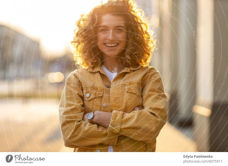 Porträt einer jungen Frau mit lockigem Haar in der Stadt natürlich Sonnenlicht urban Großstadt Hipster stylisch positiv sonnig cool Afro-Look Freude Gesundheit