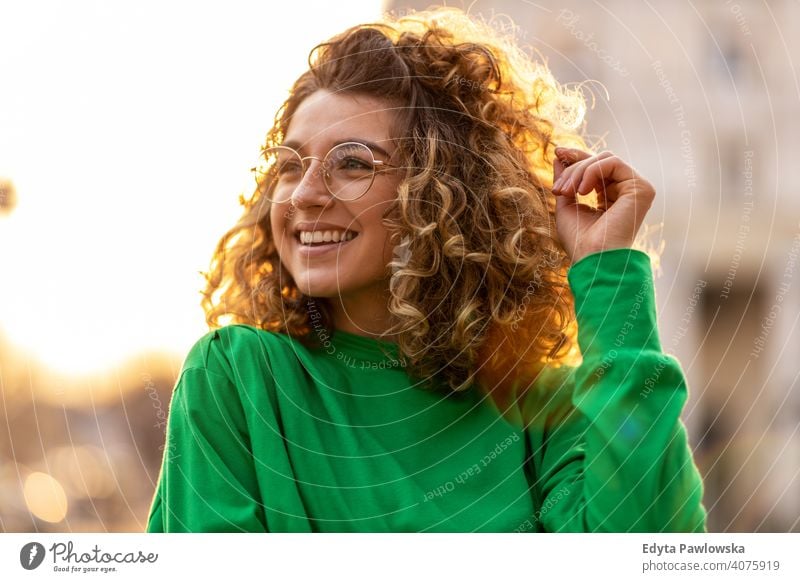 Porträt einer jungen Frau mit lockigem Haar in der Stadt natürlich Sonnenlicht urban Großstadt Hipster stylisch positiv sonnig cool Afro-Look Freude Gesundheit