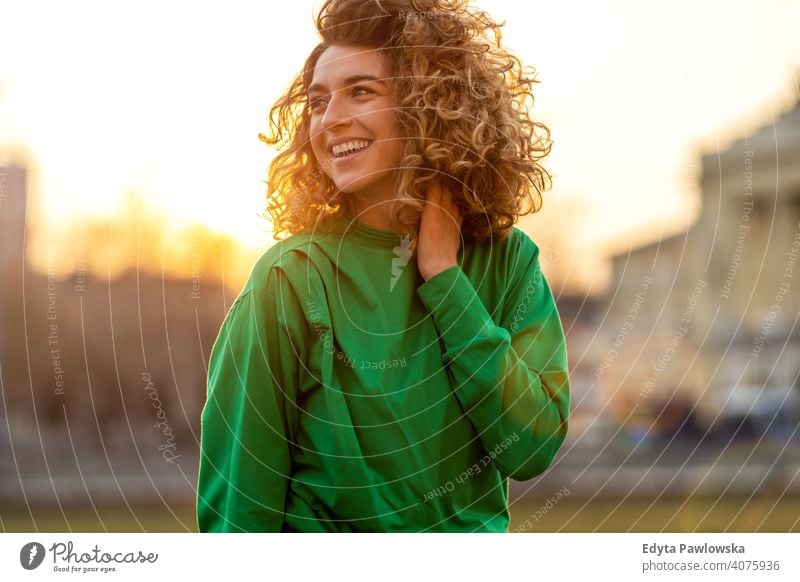 Porträt einer jungen Frau mit lockigem Haar in der Stadt natürlich Sonnenlicht urban Großstadt Hipster stylisch positiv sonnig cool Afro-Look Freude Gesundheit