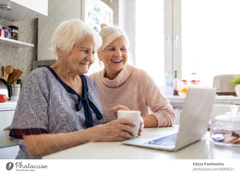 Erwachsene Tochter lehrt ihre ältere Mutter, den Laptop zu benutzen Computer Zwei Personen Bonden Familie Liebe Zusammensein besuchen Eltern Freunde freundlich