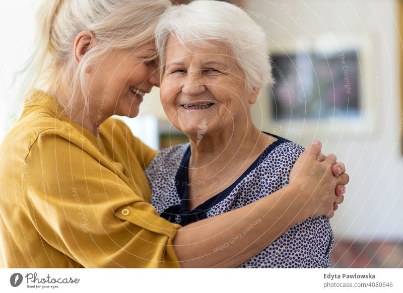 Frau, die ihre ältere Mutter umarmt Lächeln Glück genießend Positivität Vitalität Freude Selbstvertrauen Menschen Senior reif lässig Kaukasier heimwärts Haus