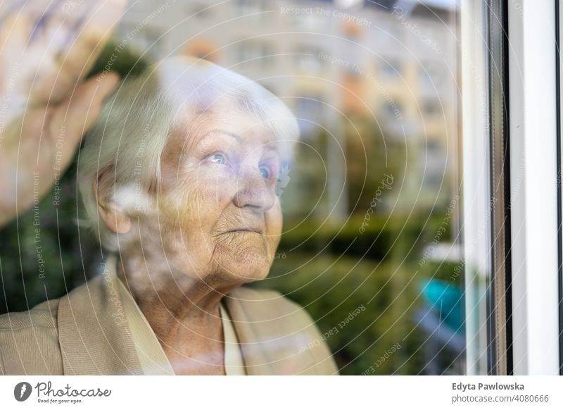 Ältere Frau schaut aus dem Fenster zu Hause traurig einsam unglücklich Depression Unsicherheit Angst beunruhigt Trauer Traurigkeit Verlust Problematik Krise