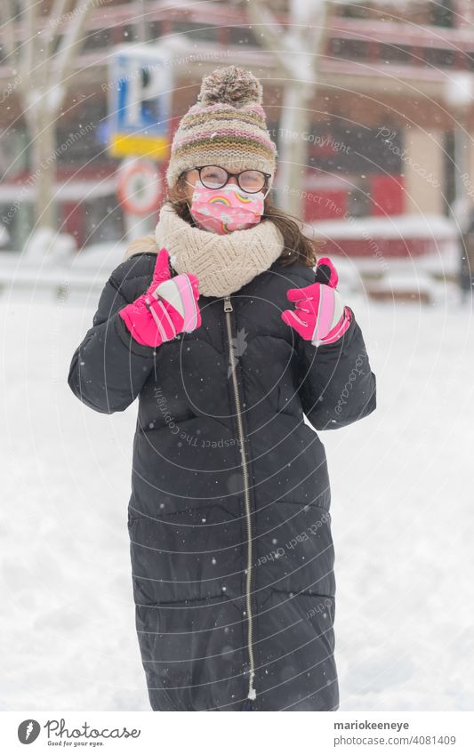 Porträt eines kleinen kaukasischen Mädchens mit einer Coronavirus-Maske und einer durch Schneefall beschlagenen Brille Unschuld Verantwortung Krankheit