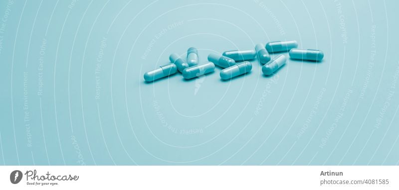 Blaue Antibiotika-Kapsel-Pillen auf pastellblauem Hintergrund. Apotheke Web-Banner. Antibiotische Medikamentenresistenz. Antimikrobielle Kapsel Pillen mit Raum. Gesundheitsbudget und -politik. Pharmazeutische Industrie.