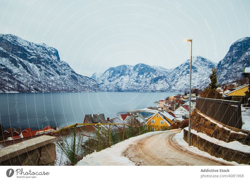 Kleine Stadt in der Nähe von Meer und schneebedeckten Bergen MEER Schnee Wolken Himmel Winter Landschaft Wasser malerisch Bucht Natur Wohnsiedlung Häuser Kamm