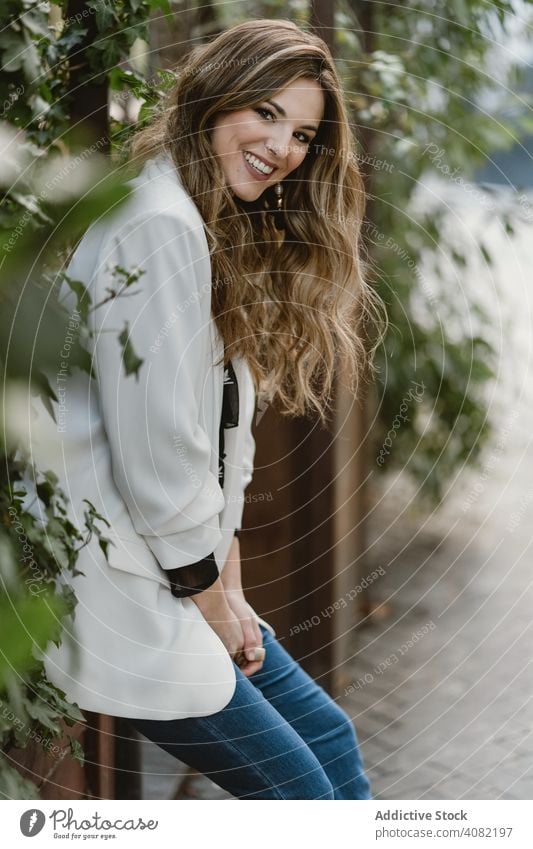 Frau sitzt auf Pflanzer im Garten Pflanzen Sitzen Jeansstoff Stil Hinterhof Straße grün Flora trendy aufgeregt Freude Glück Lifestyle Freizeit organisch